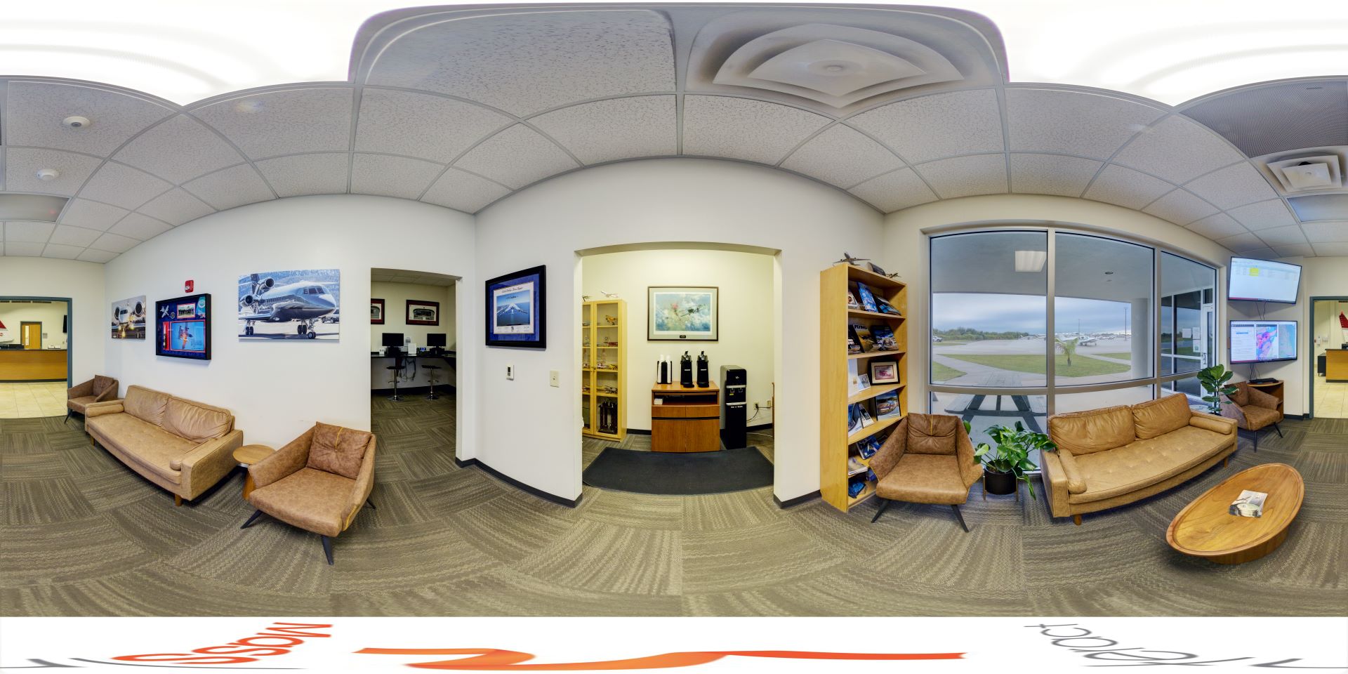 Panoramic view of a waiting room with two sofas, armchairs, and a coffee table